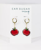 Red apple-shaped earrings on a white card with 'Ear Sugar' branding.
