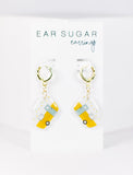 Yellow earrings with a small camper design on a white card labeled 'Ear Sugar'.