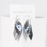 Pair of silver earrings on a white card with 'Earsugarstudios' branding.