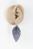 Earring worn on a mannequin ear with a white background