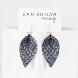 Pair of leaf-shaped earrings on a white card with 'Ear Sugar' branding.