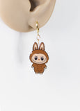 Cartoon-like brown animal earring on a mannequin ear with a white background