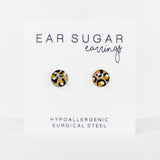 Pair of round earrings with black and yellow pattern on a white background, labeled 'Ear Sugar Earrings'.