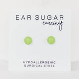 Green ear sugar earrings on a white card with text indicating hypoallergenic and surgical steel material.