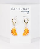 Orange slice earrings on a 'Ear Sugar' branded card against a white background