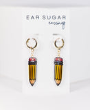 Pencil-shaped earrings on a white card with 'Ear Sugar' branding.