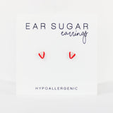 Advertisement for 'Ear Sugar earrings' with red strawberry earrings on a white background.