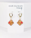 Pair of 'Ear Sugar' earrings on a white card with a light gray background